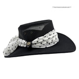 Black hat with a white polka dot scarf on a white background