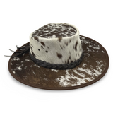 A Jacaru 1049 Rustler leather hat with a cowhide pattern and a braided leather band.
