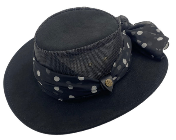 Black wide-brimmed hat with a polka dot print scarf on a white background
