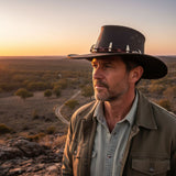 Man wearing Wallaroo Croc Hat in a desert landscape at sunset
