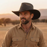 Man wearing a A black Jacaru 1066 Rizon Soft Hat and beige shirt in a desert landscape
