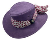 A Purple Jacaru 1103 Alice hat made from vegan leather, featuring a wide brim and a multicolored scarf adorned around the base.