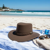Jacaru 1180 Brown Soaker Hat on a towel with sunglasses on a beach