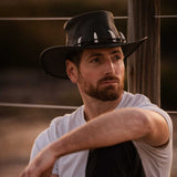 Jacaru 150 Ayers Croc Hat in black leather with crocodile‑pattern band and white tooth accents worn by man outdoors.