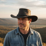 Man wearing a Roo Crushy Hatand denim shirt with a scenic background