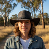Person wearing a Roo Crushy Hat in a natural setting with trees and open space.